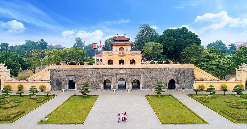 Aerial view of three people walking in front of palace