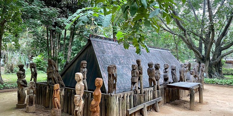 Wooden sculptures of people around dwelling sculpture