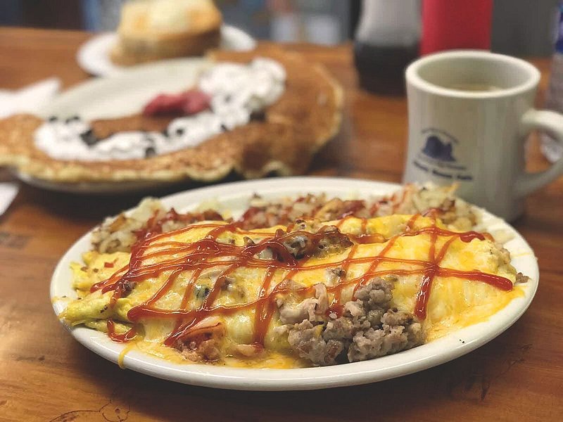 Egg and sausage omelet topped with cheese, and hashbrowns