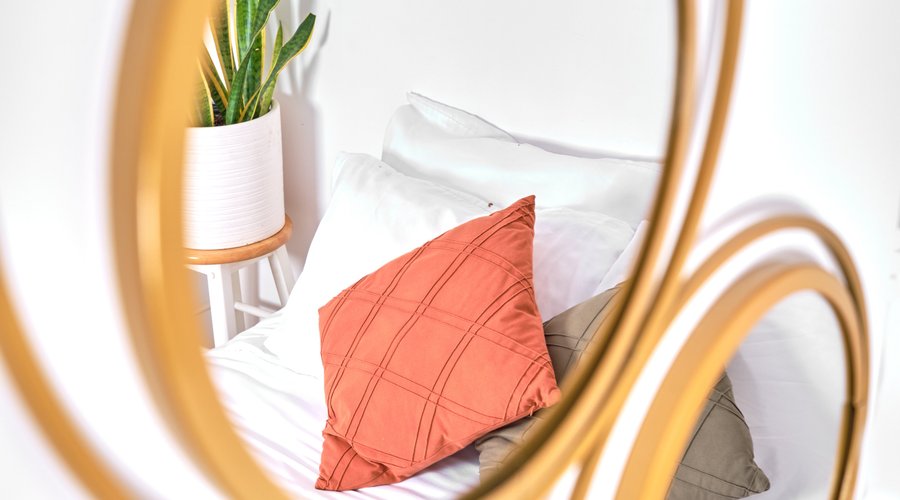 Effet de mirroir d'un grand lit queen avec coussin coloré de l'appartement 3 ½.