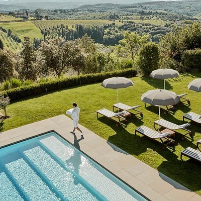 A man walking along a pool at COMO Castello Del Nero in Tuscany, Italy