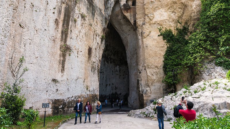 People walking outside the Ear of Dionysius at the Neopolis Archeological Park, Syracuse