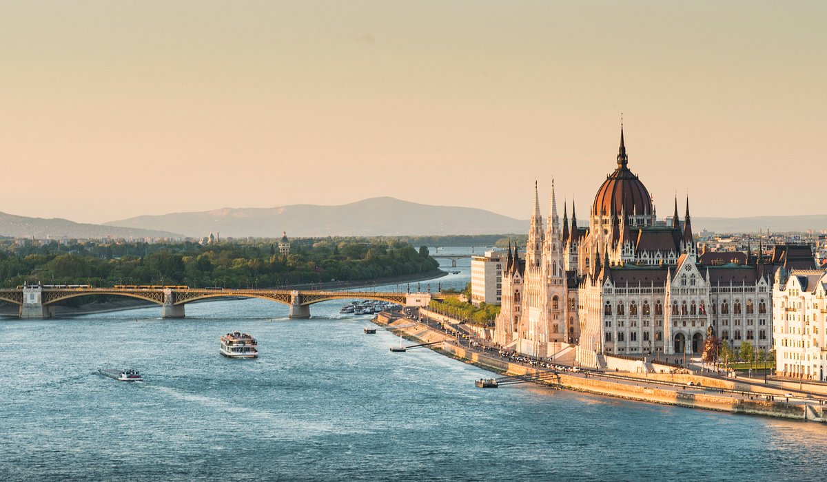 A boat sailing on the Danube river near the banks of Budapest