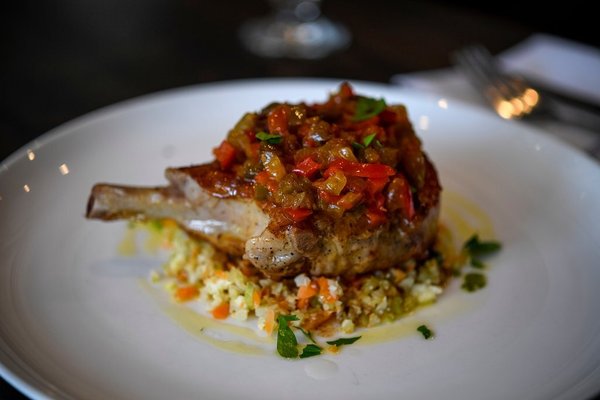 Pork chop dish atop cauliflower dish