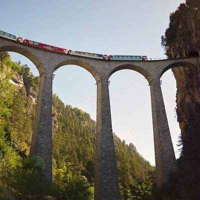 The Glacier Express in Switzerland riding on top of a bridge .