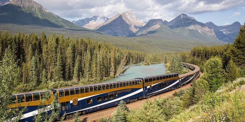 Rocky Mountaineer train on its train route through forests.