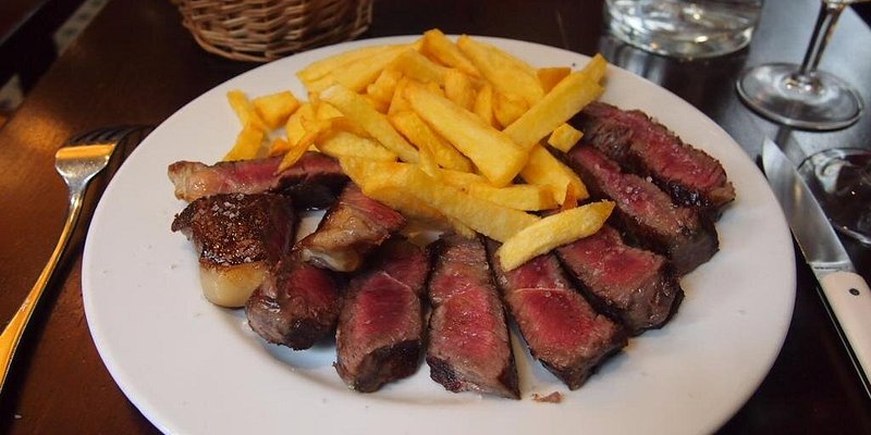 Plate of sliced steak and french fries