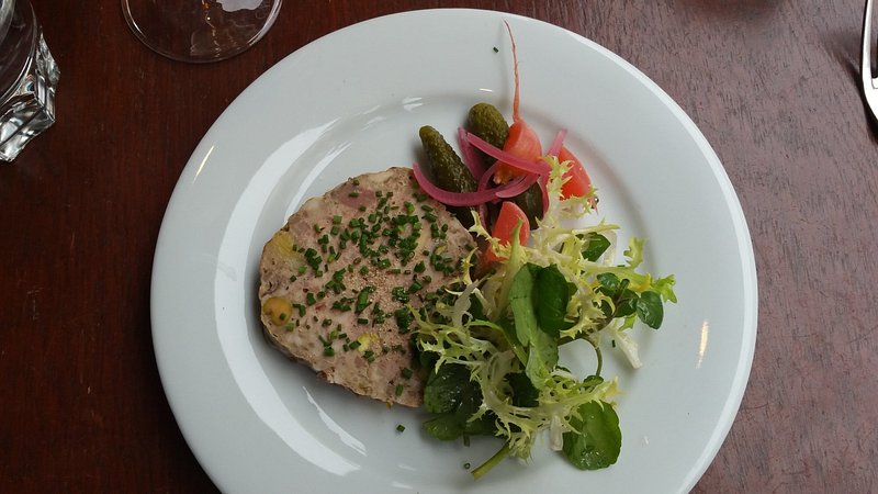 Plate of terrine with greens and pickled veggies