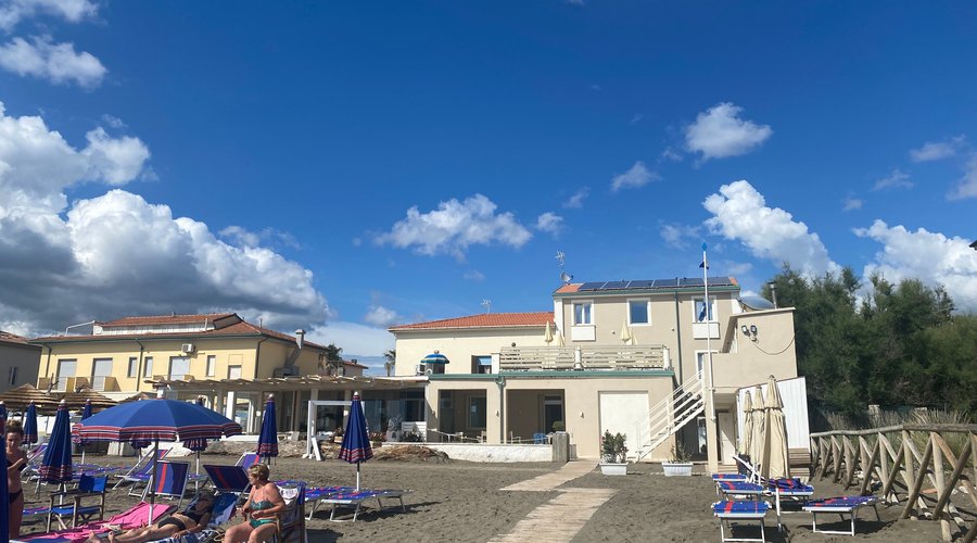Zicht op hotel vanaf strand. Patio (gedeeld) midden in beeld.