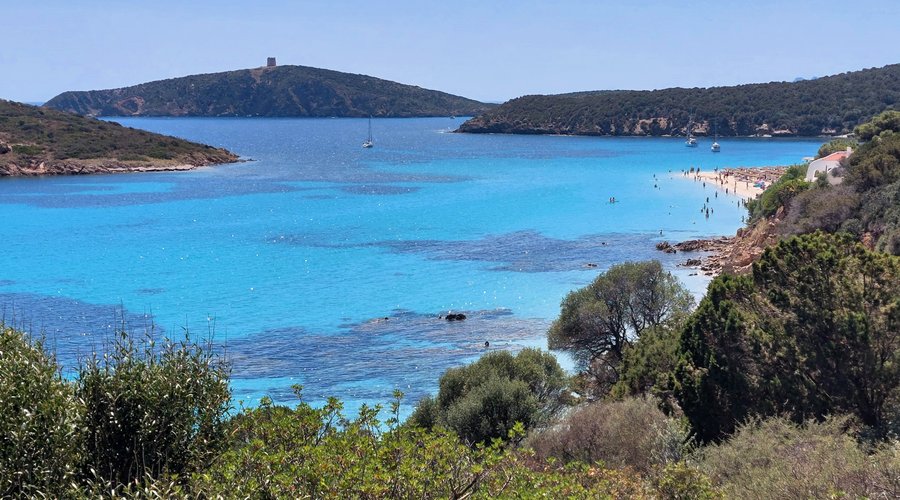 La baia della spiaggia di Tuerredda, di cui si vede uno scorcio a dx