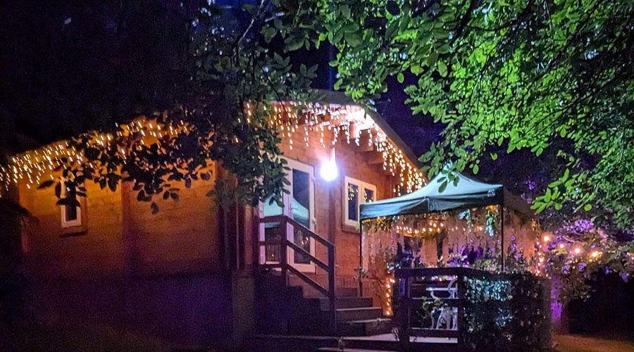 Swan Lodge with hot tub at night with lights.
