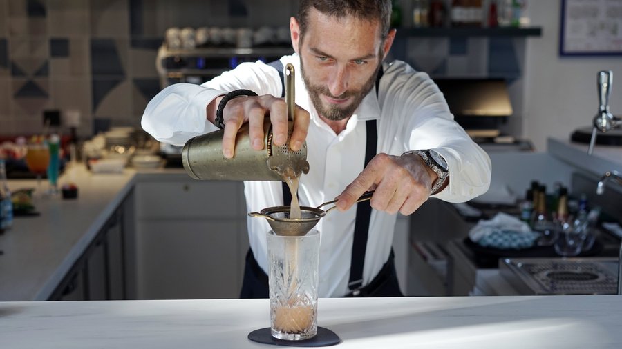 Our Cucina Victoria barman preparing a cocktail.