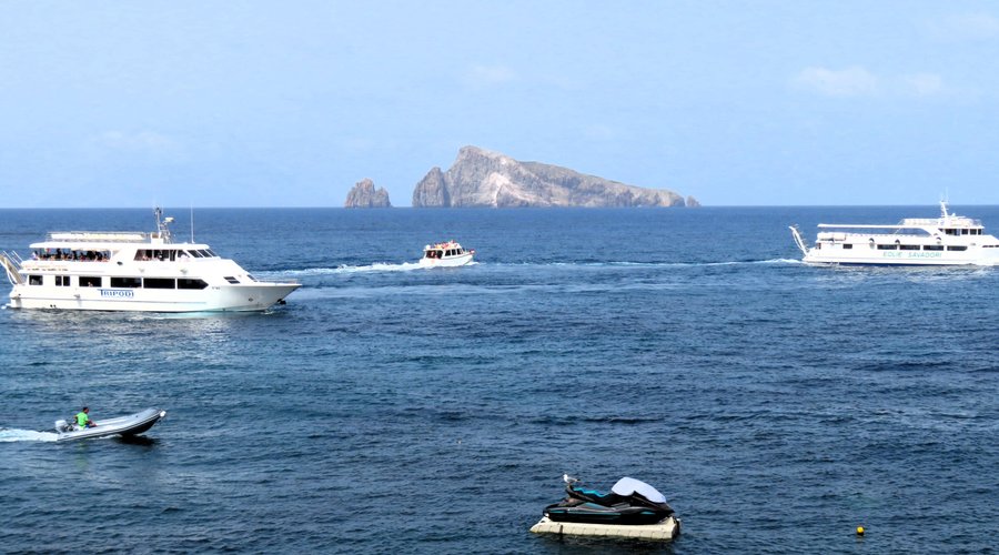 Il via vai delle barche dal porticciolo di Panarea e sullo sfondo l'isolotto di Basiluzzo