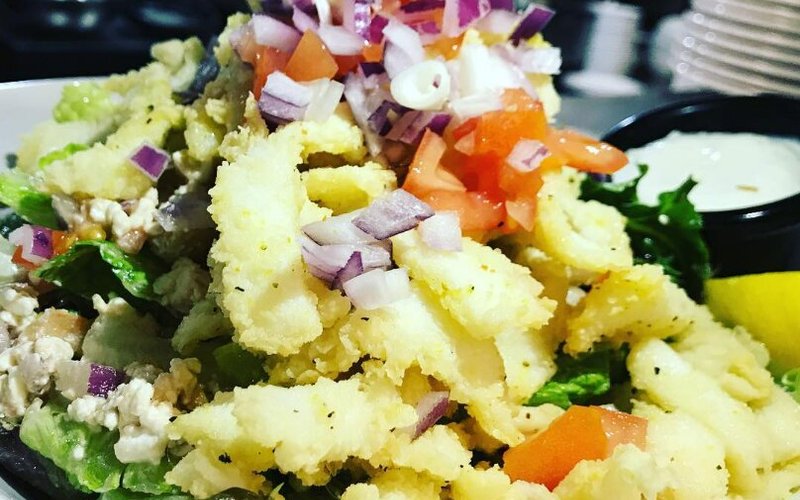 A hit since day one: our Calamari Salad. Made with Humboldt squid, gently fried on top of fresh greens, feta, tomatoes & onions, tossed in our balsamic vinaigrette. 