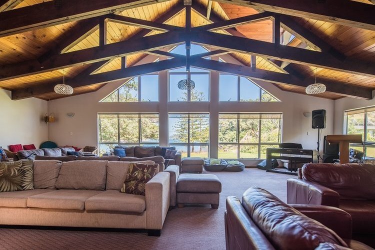 Communal lounge with bay views, afternoon sun, and a fireplace for winter