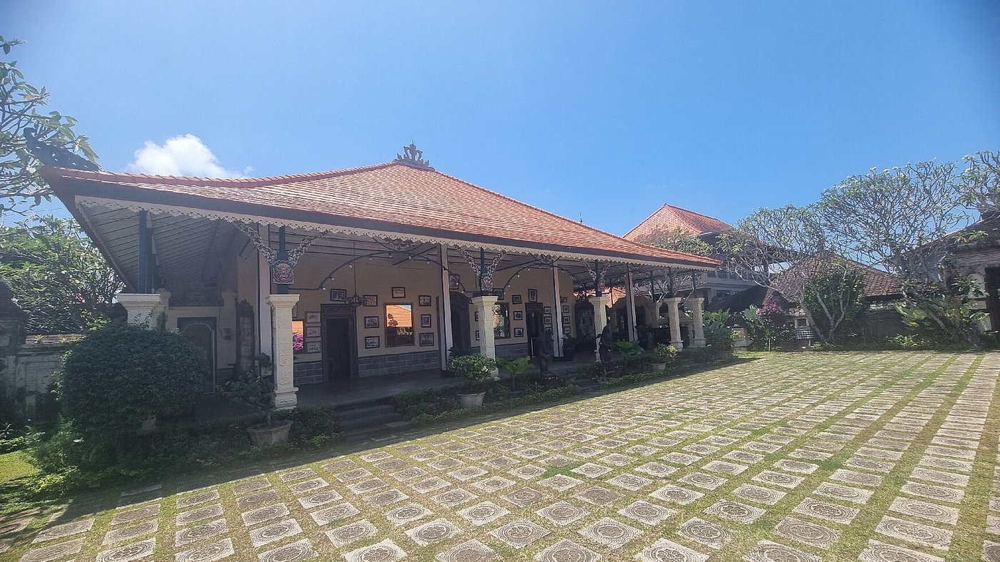 A traditional Balinese royal residence with classic architecture and spacious courtyard under a bright sky, featured in a Bali heritage tour.