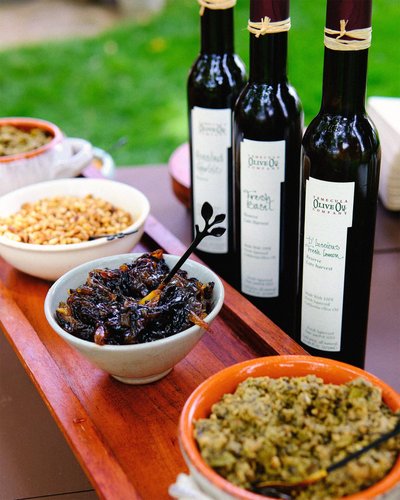 Table topped with olive oil bottles and bowls of food