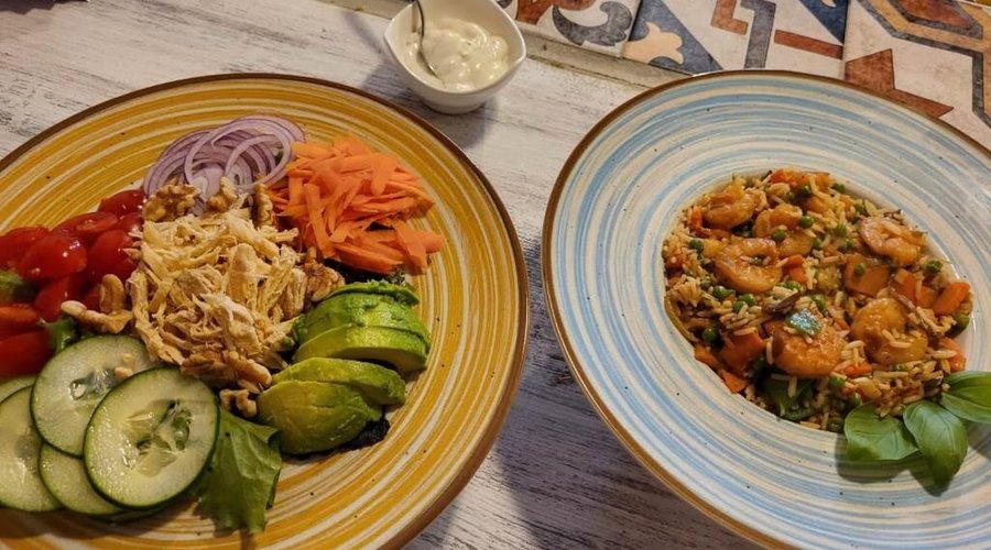 Deliciosos pratos de almoço, como wok com camarões e saladas frescas