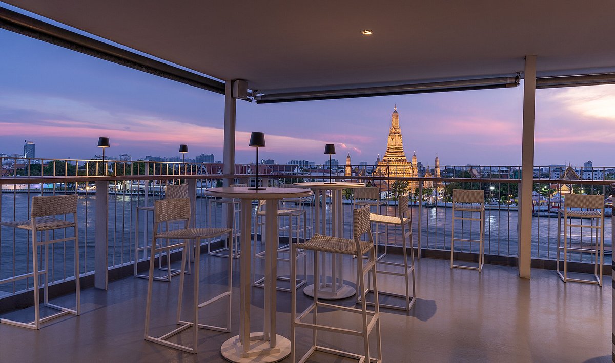 Espaço interno do restaurante com vista para o rio de Bangkok