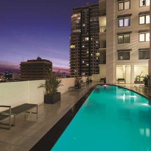 Outdoor swimming pool at night with poolside chairs
