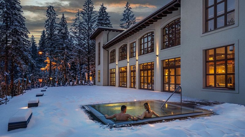 Couple soaking in outdoor hot tub at night