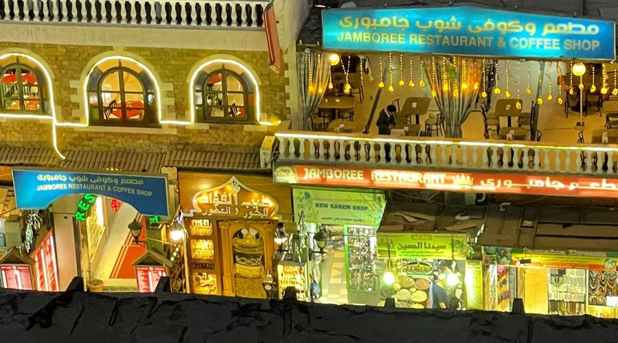 The brilliance of Jamboree restaurant at night amidst the crowd of pedestrians in the old Luxor market