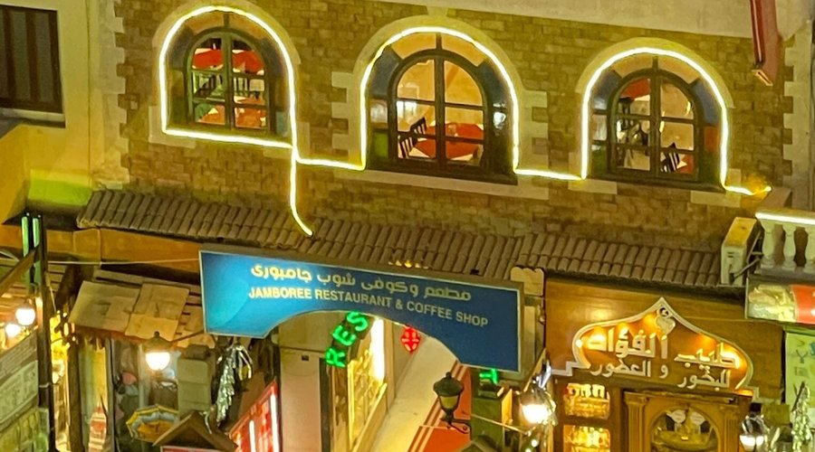 The brilliance of Jamboree restaurant at night amidst the crowd of pedestrians in the old Luxor market
