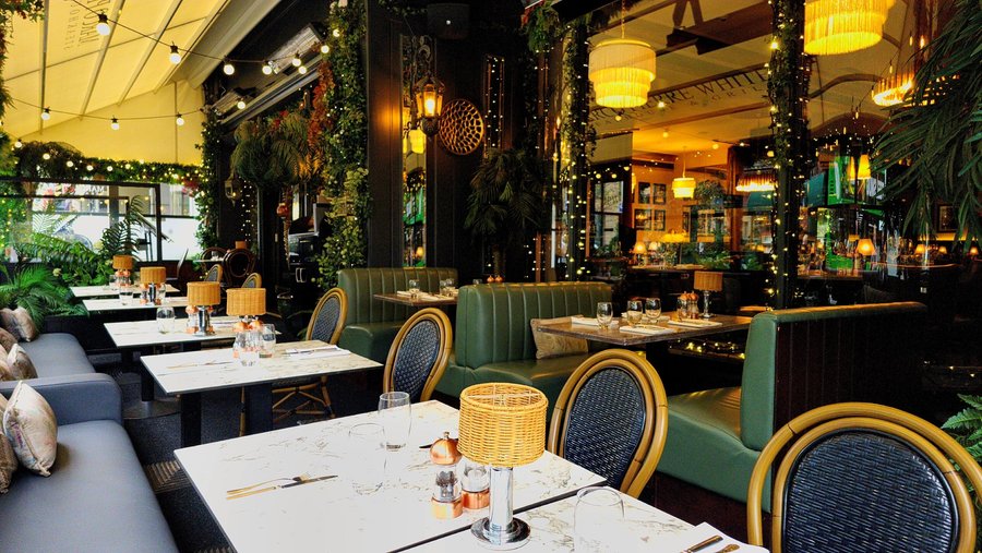 Charming terrace at Marco Pierre White Steakhouse & Grill Dawson St, featuring cosy seating, soft lighting, lush greenery, and elegant table settings, creating a warm and inviting outdoor dining experience in Dublin.