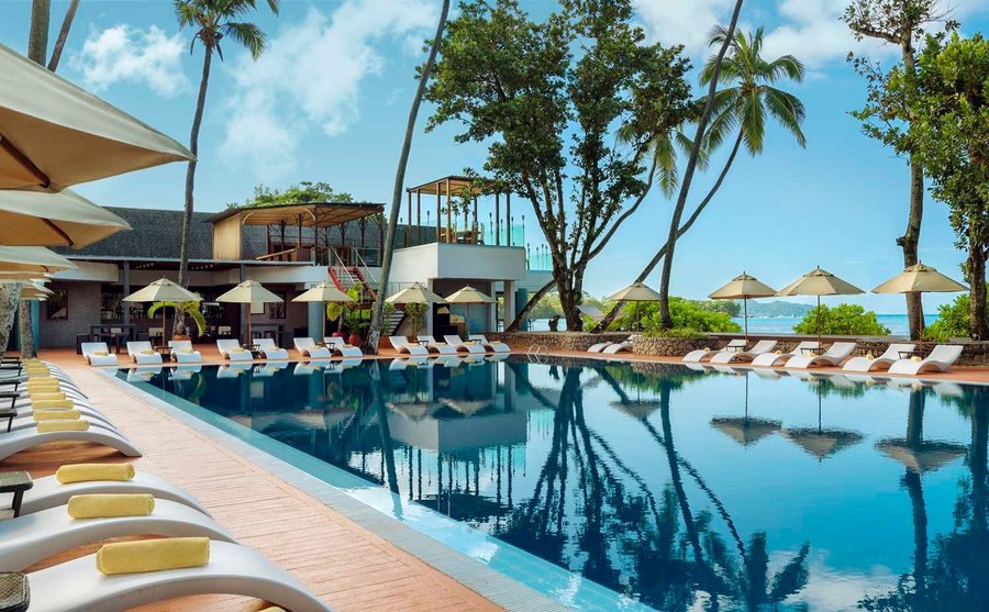 Exterior view of swimming pool with sun-loungers and umbrellas 