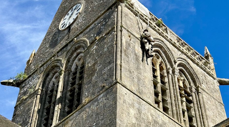 The 11th-century Sainte-Mère-Église church has an unusual attraction. Look up towards the steeple and you will see a dummy of John Steele, the American WWII paratrooper, who got snagged on the steeple during the D-Day attack and had to hang there for hours before he was cut down.