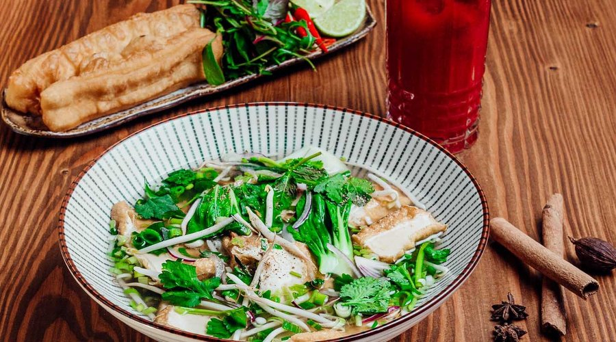 🍜 Pho Tofu (Vegan) Eine herzhafte, aromatische vietnamesische Reisbandnudelsuppe – ganz ohne Fleisch, aber voller Geschmack! Unsere vegane Pho wird mit einer duftenden, klaren Brühe aus Sternanis, Zimt, Ingwer und gerösteten Zwiebeln zubereitet. Dazu gibt es zarte Reisbandnudeln, knusprig angebratenen Tofu und eine Vielfalt an frischem Gemüse wie Pak Choi und Sojasprossen. Abgerundet mit duftenden Kräutern wie Koriander, Thai-Basilikum und Minze sowie einem Spritzer Limette.
