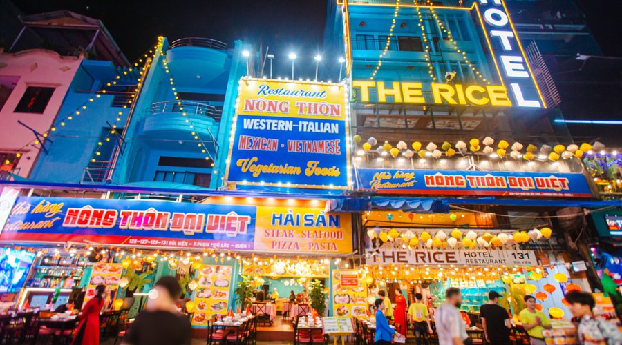 Mặt tiền khách sạn The Rice Hotel phía dưới là nhà hàng Nông Thôn Đại Việt nằm giữa phố tây Bùi Viện vô cùng sôi động khi đêm về