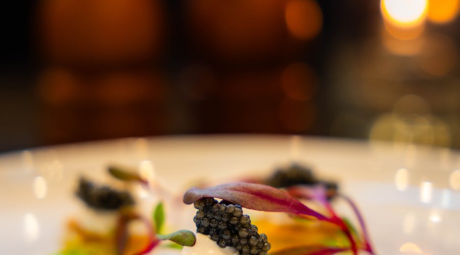 Caviar served atop Duck Confit Potato crisps & Truffle Crema, garnished with a chive gel