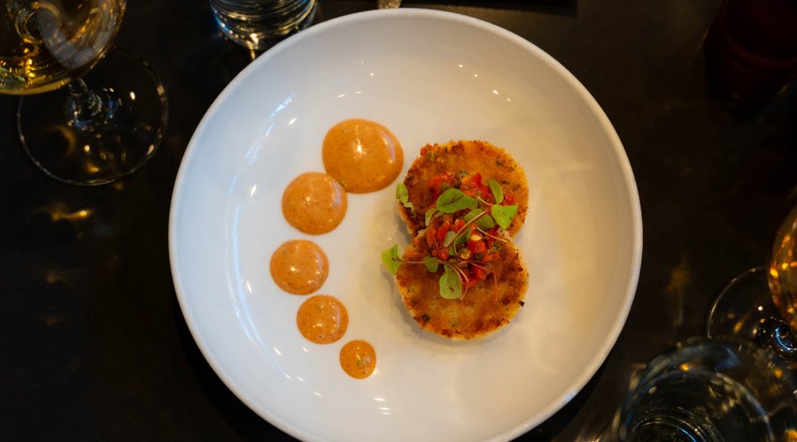 Crab Cakes garnished with Red Pepper Relish, served with a Cajun Remoulade