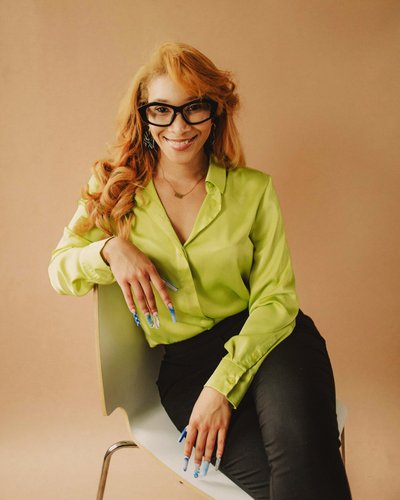 Portrait of Shannon Johnson wearing green blouse and sitting on a chair 