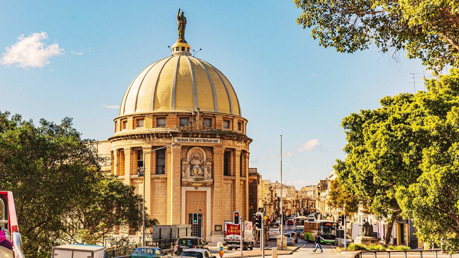 Iglesia amarilla con un techo abovedado y una escultura en la parte superior