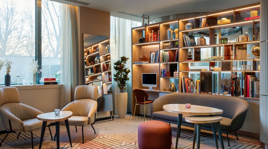 Bookcase, chairs and sofas with coffee tables