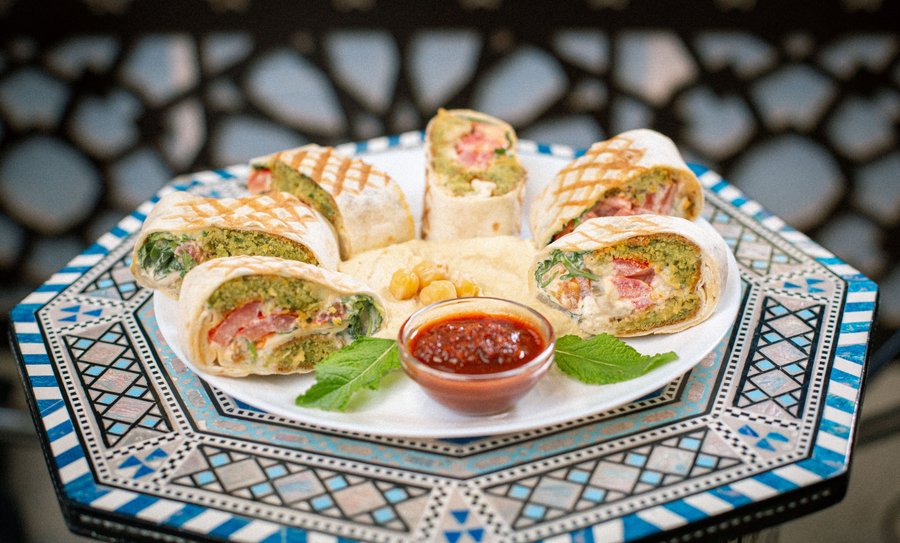 Découvrez notre délicieux Falafel Shawarma : un sandwich de falafels découpés en tranche, accompagné de son houmous et d'une touche de sauce piquante. Un festival de saveurs avec des falafels croustillants, des tomates fraîches, de la roquette, de la menthe parfumée, des cornichons et une généreuse sauce tahini au sésame. 