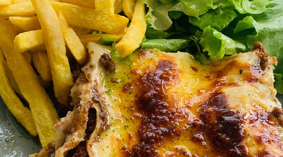 Lasanha servida com batata frita e salada