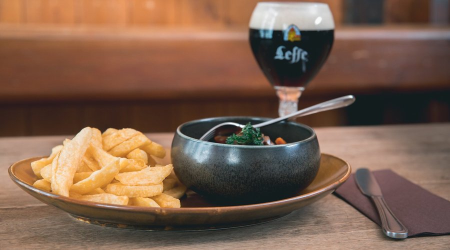 Carbonade à la Flamande & Leffe Brune – Tradition Belge Découvrez notre carbonade à la flamande, un ragoût mijoté lentement dans une bière brune, avec du pain d’épices, de la moutarde et des oignons, offrant une sauce onctueuse et parfumée. Servie avec des frites croustillantes, elle se marie parfaitement avec une Leffe Brune, aux notes de caramel et d’épices. Un classique belge, réconfortant et gourmand, à déguster avec une vue sur la Grand-Place !
