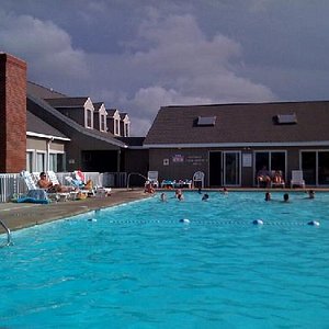 Pool with indoor pool/hot tub in background.  Activities building on left.